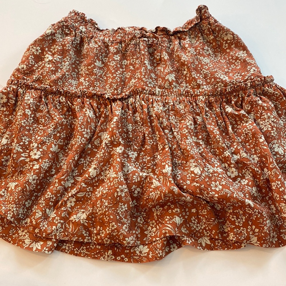 This Zara skirt includes a tight waist band and cute subtle ruffles. It’s a 14.